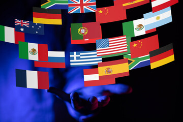 Image of hands gently holding various national flags, symbolizing international collaboration and...