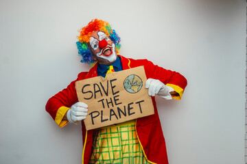 Clown holding 'save the planet' sign