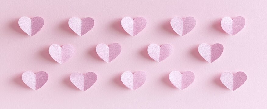 Delicate pink hearts arranged on a pastel background