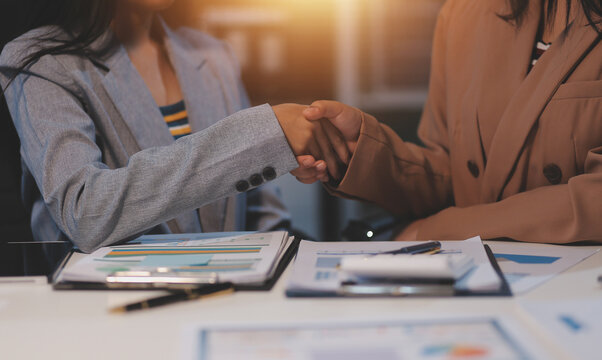 Man and woman are shaking hands in office. Collaborative teamwork.