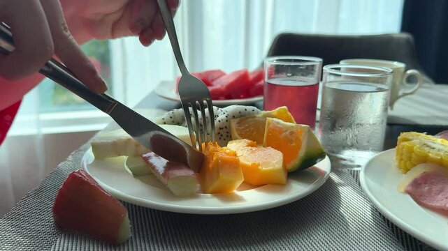 cut papaya fruits for breakfast cut a piece of papaya with a knife and fork fruits fly carelessly in all directions tropical side breakfasts at the hotel