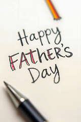 Obraz premium A creative Father's Day greeting written in playful, hand-drawn black and red letters on white paper, with a pen placed nearby, conveying a personal and heartfelt message for the occasion.