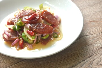 spicy and sour sweet slice Chinese pork sausage with vegetable salad on plate  