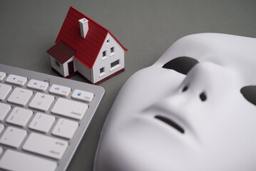 House, keyboard computer, white mask scammer on gray background. Real estate, property, land, rental, mortgage closing scams concept. Protect money from real estate scams when buying, rental a home.