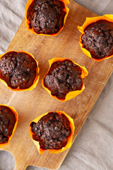 Homemade Chocolate Chip Muffins on a wooden board, top view.
