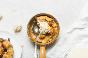 Overhead view of homemade bread pudding with vanilla ice cream, top view of fresh bread pudding with cream