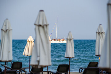 table and chairs on the beach and boat on the sea