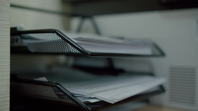 Hand placing documents in office paper tray