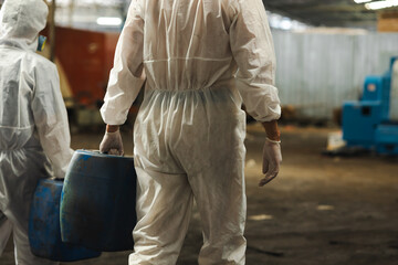man holding Old plastic barrels containing toxic chemicals : Officials from the Department of...