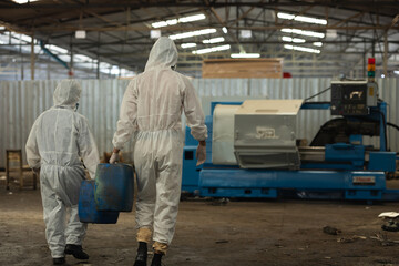 Fototapeta premium man holding Old plastic barrels containing toxic chemicals : Officials from the Department of Hazardous substances control bureau investigating leak of hazardous chemical in chemical industry plant