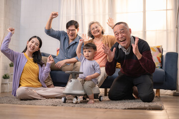 Family enjoys a joyful moment while celebrating together in their cozy living room with a child riding a toy