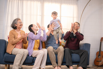 Family celebrates together in living room while enjoying time with young child on a cozy afternoon