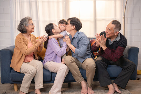 Family gathers in cozy living room for joyful celebration with child on a sunny afternoon