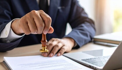 close-up shot of a hand applying a legal stamp to a contract in an office, signifying the final approval and authentication of important business documents.