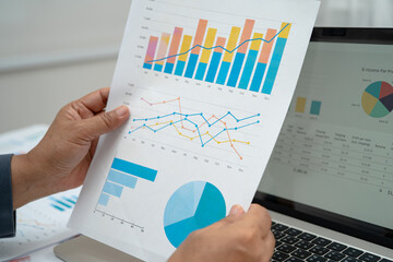 Asian business woman working with financial graph.