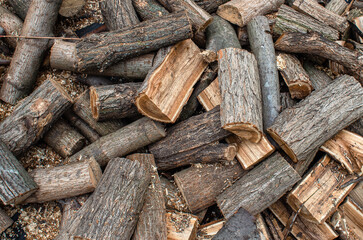 Pile of chopped firewood scattered on surface. Stacking firewood. Chopped firewood for winter....