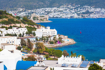 Panoramic view of Bodrum coast in Turkey with white buildings, turquoise Aegean Sea and medieval Bodrum Castle on hill. Bright summer day with clear sky and vivid natural colors