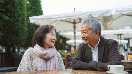 カフェテラスで会話を楽しむ日本人シニア夫婦