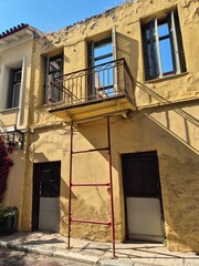 Balcony of dilapidated building held up by simple metal device