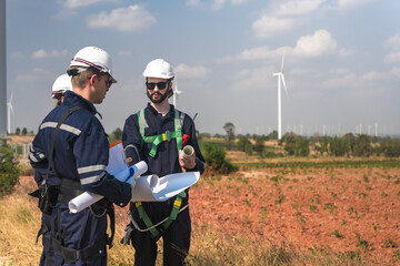 Male wind turbine engineers team discussing on project blueprint in windmill field