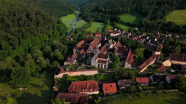 Drone footage over Bebenhausen Monastery and Castle in lush woods on Bromberg Hill, showcasing medieval walls, church towe, baroque architecture in southern Germany. Kloster und Schloss Bebenhausen. 