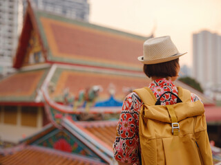 Obraz premium Woman Exploring Colorful Streets Near Buddhist Temples in Bangkok