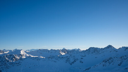 Aussicht auf alpine Schneelandschaft mit Wolkenmeer bei blauem Himmel
