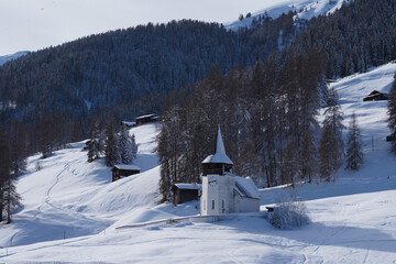 Kleine Kirche in einer verschneiten Berglandschaft in den Schweizer Alpen