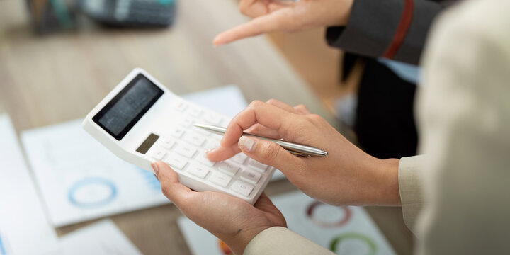 Financial Analysis and Calculation. Professionals using calculator for project budgeting.