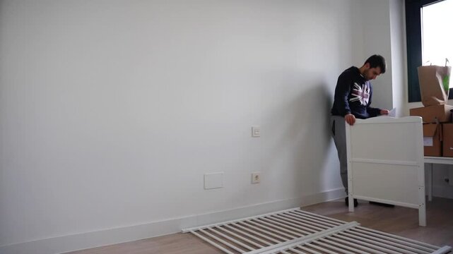 Man assembling a crib for the baby in fast motion finishing at night
