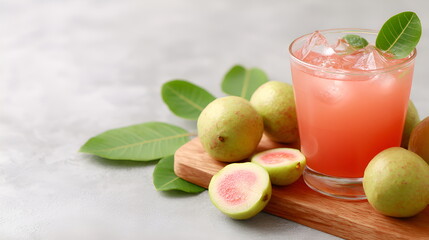 Fototapeta premium Juicy guava juice in glass with ice and fresh guava slices beside