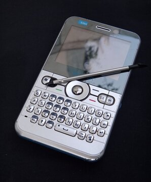 Old Tmn Smartphone With Stylus On Keyboard On Black Background