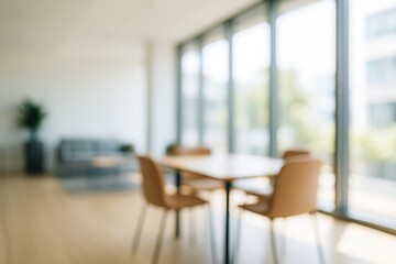 Blurred interior view of a modern office lounge or coworking space with a table and chairs, offering abstract background for design.