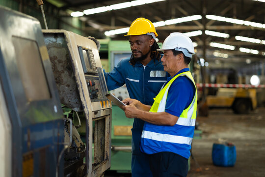 Two engineering man : African american male Manufacture technical and Asian man factory staff working while Using digital tablet computer at industry factory