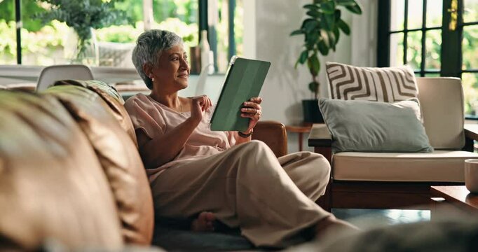 Sofa, senior woman and laughing with tablet for online streaming, news website and relax at home. House, old person and thinking with digital for application, chat and social media post in retirement