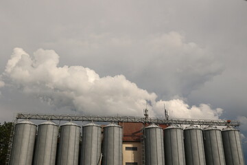 Row of silos are lined up in front of a cloudy sky