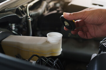 Hand Opening Brake Fluid Reservoir Cap in Engine bay, Automotive Maintenance Checking Brake Fluid Level.