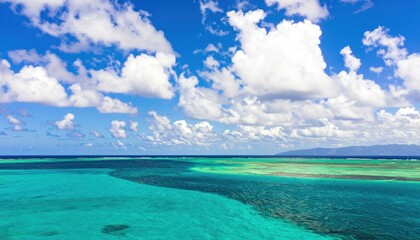 Fototapeta premium Breathtaking caribbean turquoise waterscape under a vibrant blue sky filled with fluffy clouds