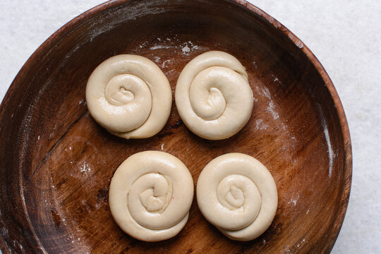 Overhead view of rolled paratha dough, top view of flaky flatbread dough, process of making paratha	