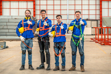 Four construction workers wearing safety gear and smiling at the camera.