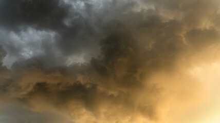 Dramatic Golden Cloudscape with Dark Stormy Clouds and Warm Sunlight Creating a Majestic Sky Scene for Nature and Weather Photography Enthusiasts