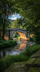 Sunlit historic stone bridge spans a tranquil river amid lush greenery.









