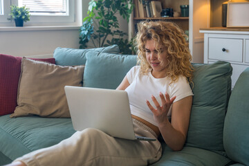 Young woman working from home on laptop experiencing technical issues such as internet...