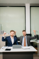 Two office colleagues discuss ideas for a startup project in a modern workspace, using laptops and smartphones