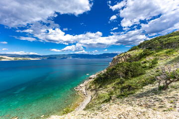 Fototapeta premium Hiking trail leading from the beach in Baska to the Bag mountain, city panorama seen from above,
