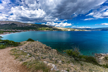 Hiking trail leading from the beach in Baska to the Bag mountain, city panorama seen from above,