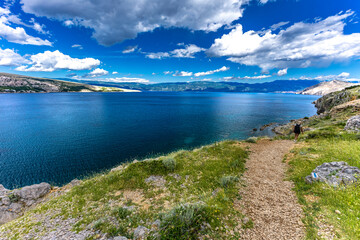 Hiking trail leading from the beach in Baska to the Bag mountain, city panorama seen from above,
