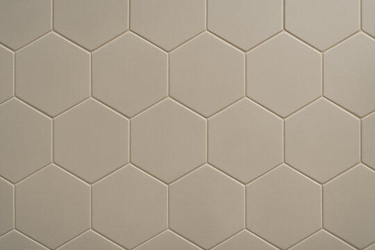 Honeycomb Harmony: A close-up shot reveals a repeating pattern of precisely arranged, light-colored, hexagonal tiles, embodying a sense of order and geometric perfection.