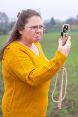 Angry Mature white woman yelling furiously on the phone, expressing frustration and emotional instability, anger and mental exhaustion