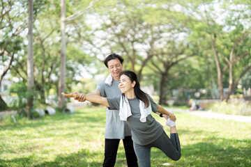 Couple enjoying playful yoga moments in the park